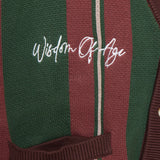 Closer Look at top right chest of the front of the cardigan with the brand name "Wisdom of Age" embroidered in a handwritten script cursive.