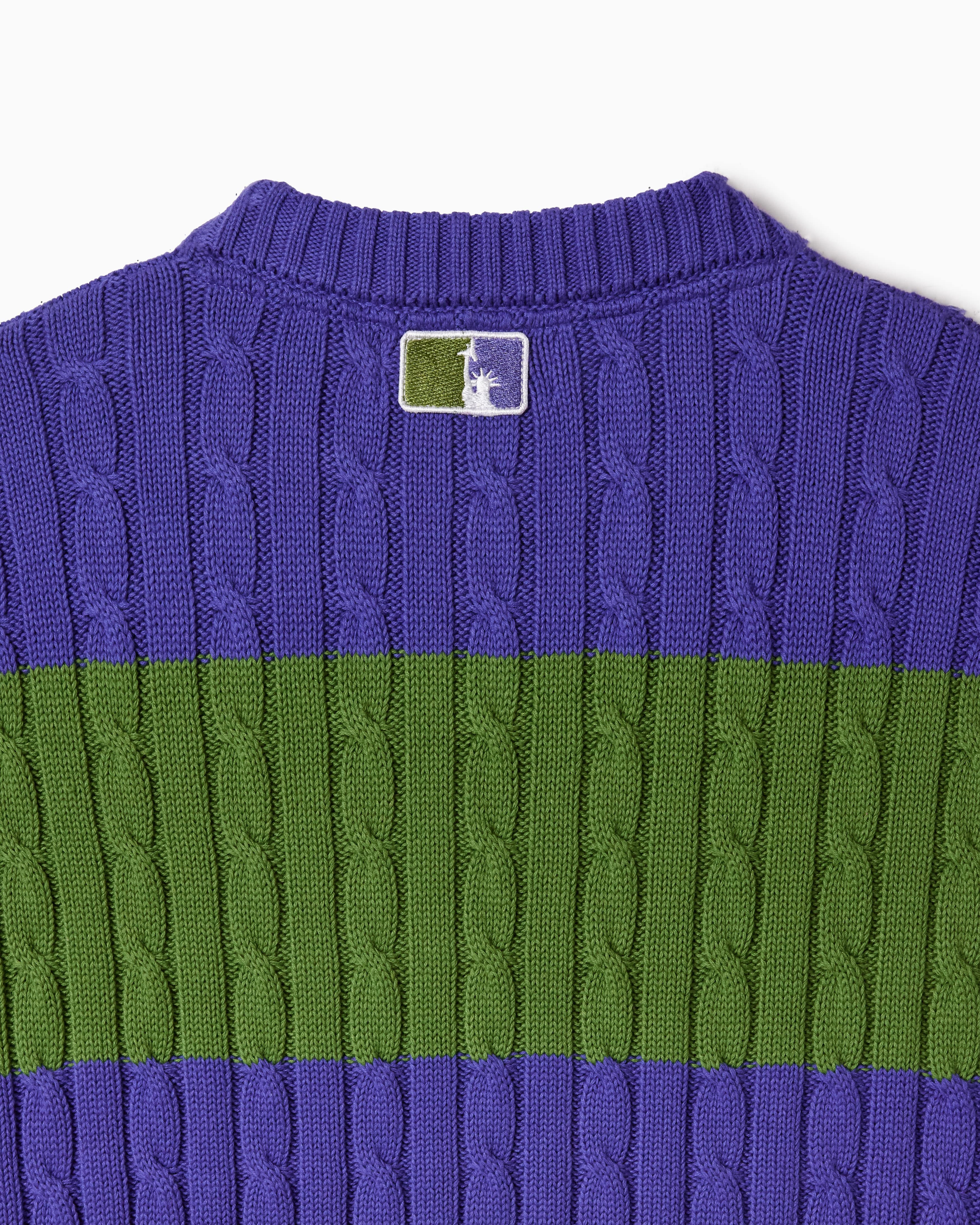 Purple and green cable knit T-shirt with the WOA Liberty logo on a white background