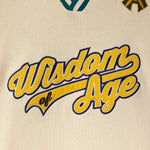 Cream knitted baseball jersey with 'Wisdom of Age' in script text in yellow and navy