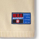 Beige knit baseball jersey tag with a W.O.A. Sport label
