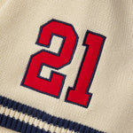 Red number 21 on a cream knitted baseball jersey with navy border