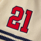 Red number 21 on a cream knitted baseball jersey with navy border