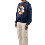 Side view of a Male Model wearing a navy sweatshirt with a logo and beige cargo pants on a white background