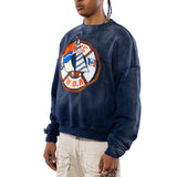 Side close view Male Model wearing a navy sweatshirt with a logo and beige cargo pants on a white background