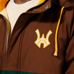 Close up of Brown jacket with yellow hood and embroidered 'WA' logo with a yellow outline on a white background