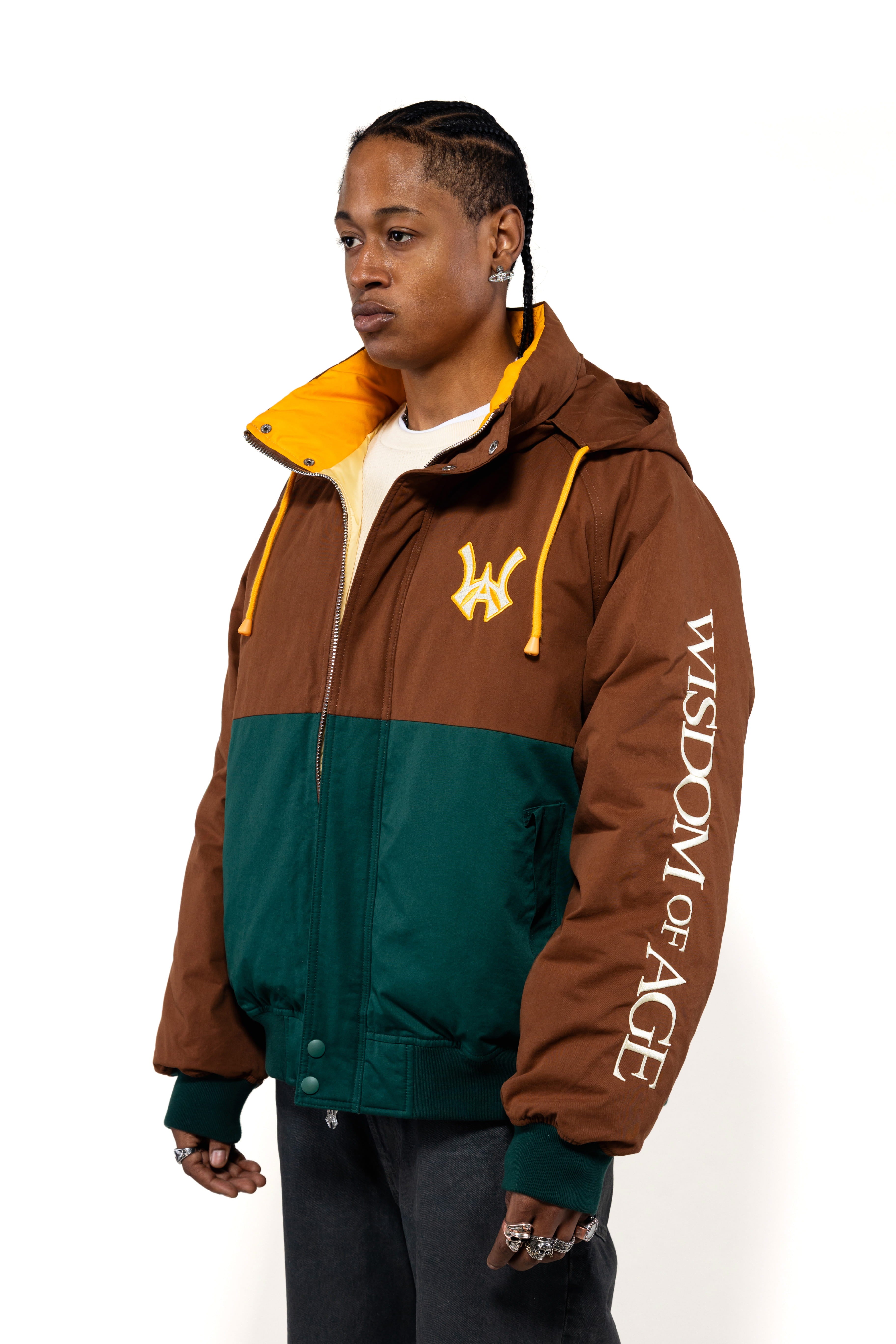 Side view of a Male Model wearing a brown and forest green jacket with yellow accents on a white background.