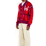 Full body side view of a Male Model Wearing the Wisdom Of Age City Cardigan in Red Velvet on a white background.