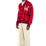 Full body side view of a Male Model Wearing the Wisdom Of Age City Cardigan in Red Velvet on a white background.
