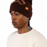 Male Model wearing a brown beanie with the 'WA' logo and the WOA Cream thermal on a white background.