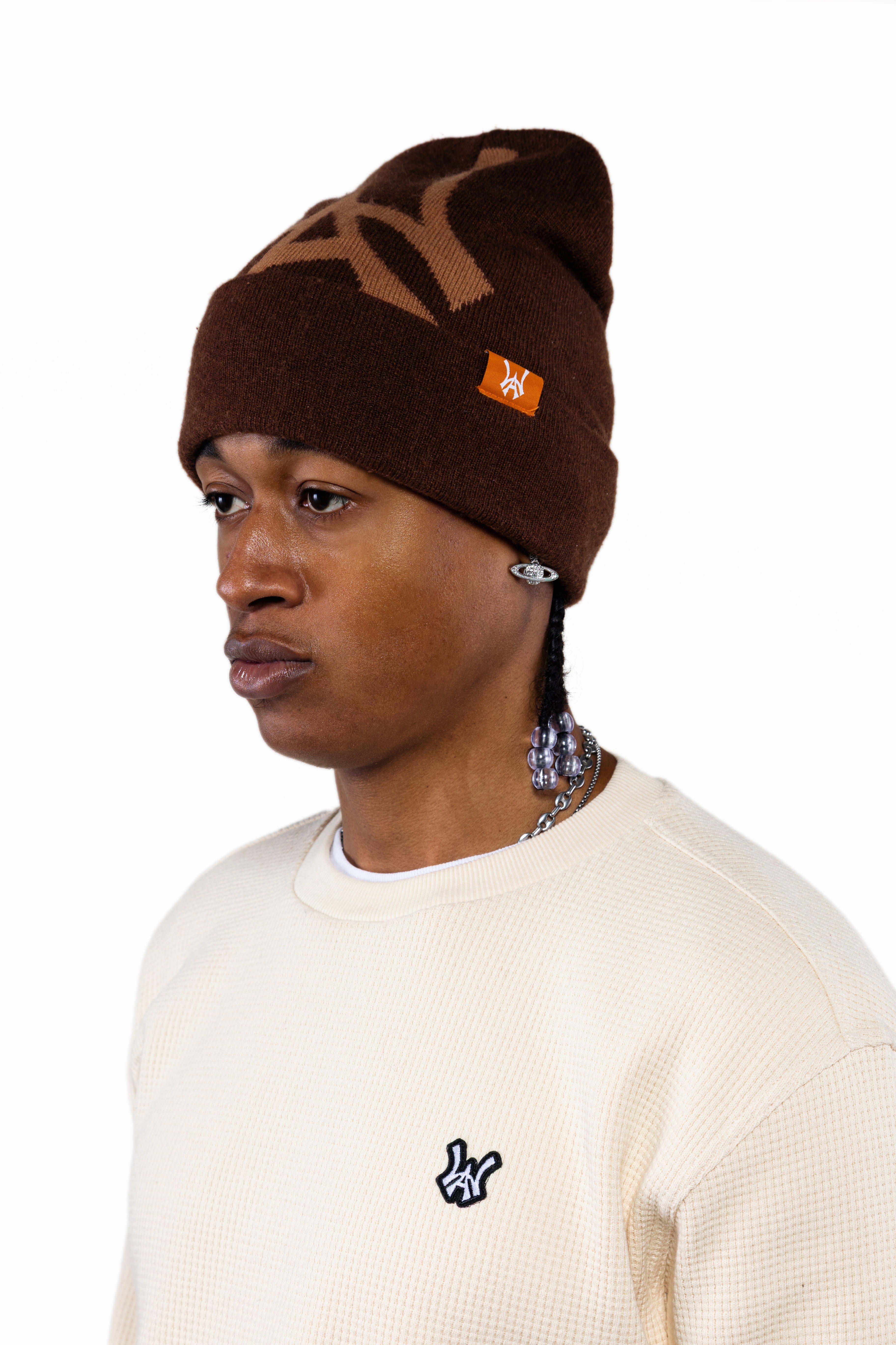 Male Model wearing a brown beanie with the 'WA' logo and the WOA Cream thermal on a white background.