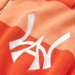 Close Up on the Front view of the WOA knit hoodie. WA logo embodied on the left chest in between the alternating orange stripes.