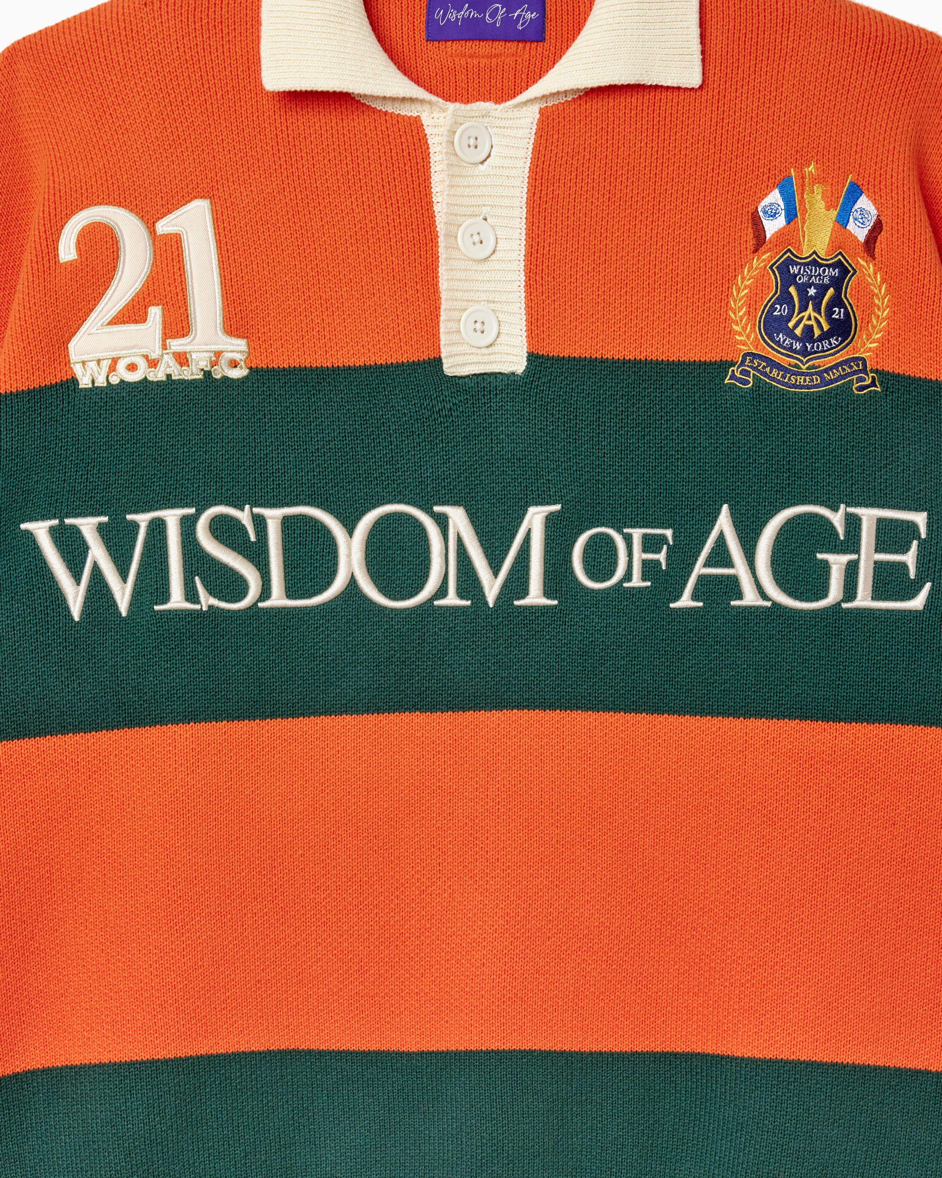 Orange and green striped rugby Sweater with 'Wisdom of Age' embroidered .