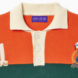 Close up of the Orange and green rugby sweater with a Wisdom Of Age label on a white background