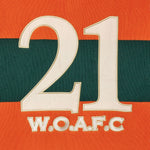 Close-up of the embroidery of the number 21 and 'W.O.A.F.C.' on an orange and green background