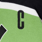 Close-up of a sports jersey with a letter 'C' on a green and black background