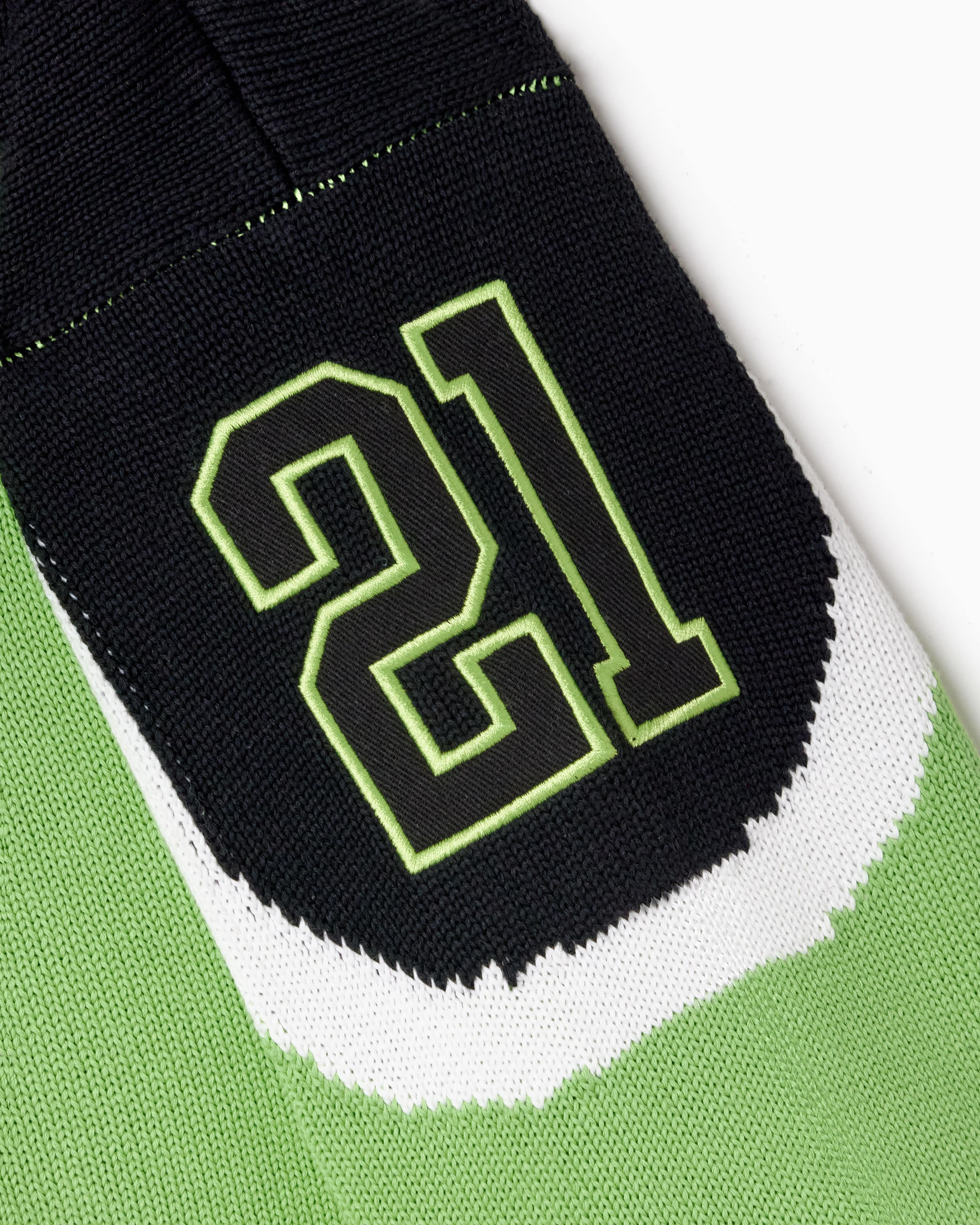 Close-up of a green and black Sleeve with the number 21 on a white background