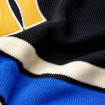 Close-up of a sports jersey with a logo and color-blocked design.