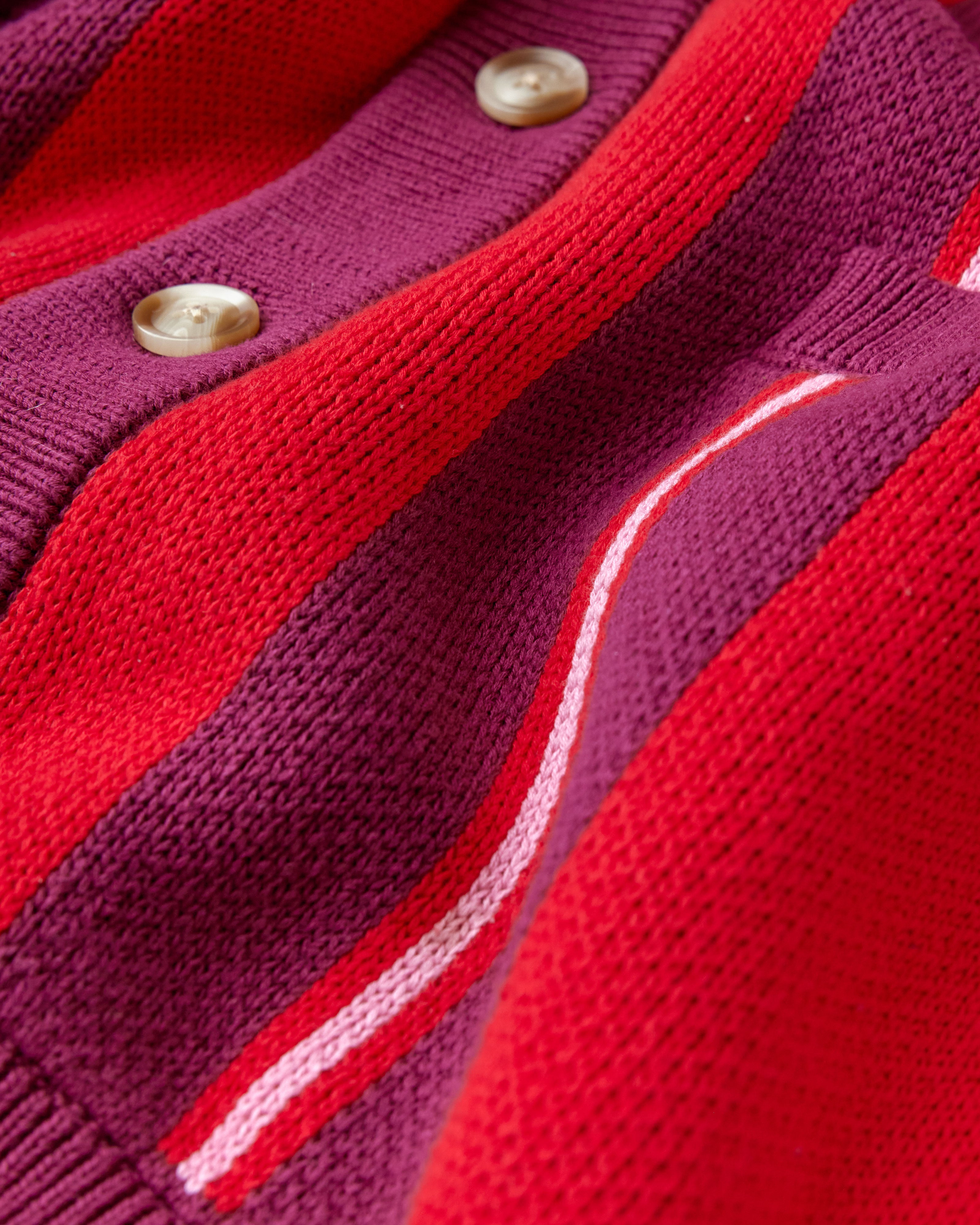 Close-up of a red and purple cardigan with button details