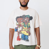 Male model wearing a off-white t-shirt with cartoon characters and olive cargo pants on a light gray background