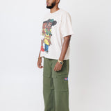 male model wearing a off-white t-shirt with cartoon characters and olive cargo pants on a light gray background
