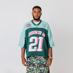 Male Model wearing a the WOA Football jersey V2 in the Mint color with 'Wisdom Of Age' and number '21' embroidered on the front. Model is wearing the WOA Camo Cargos on a white background.