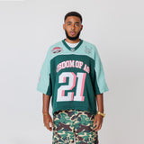 Male Model wearing a the WOA Football jersey V2 in the Mint color with 'Wisdom Of Age' and number '21' embroidered on the front. Model is wearing the WOA Camo Cargos on a white background.