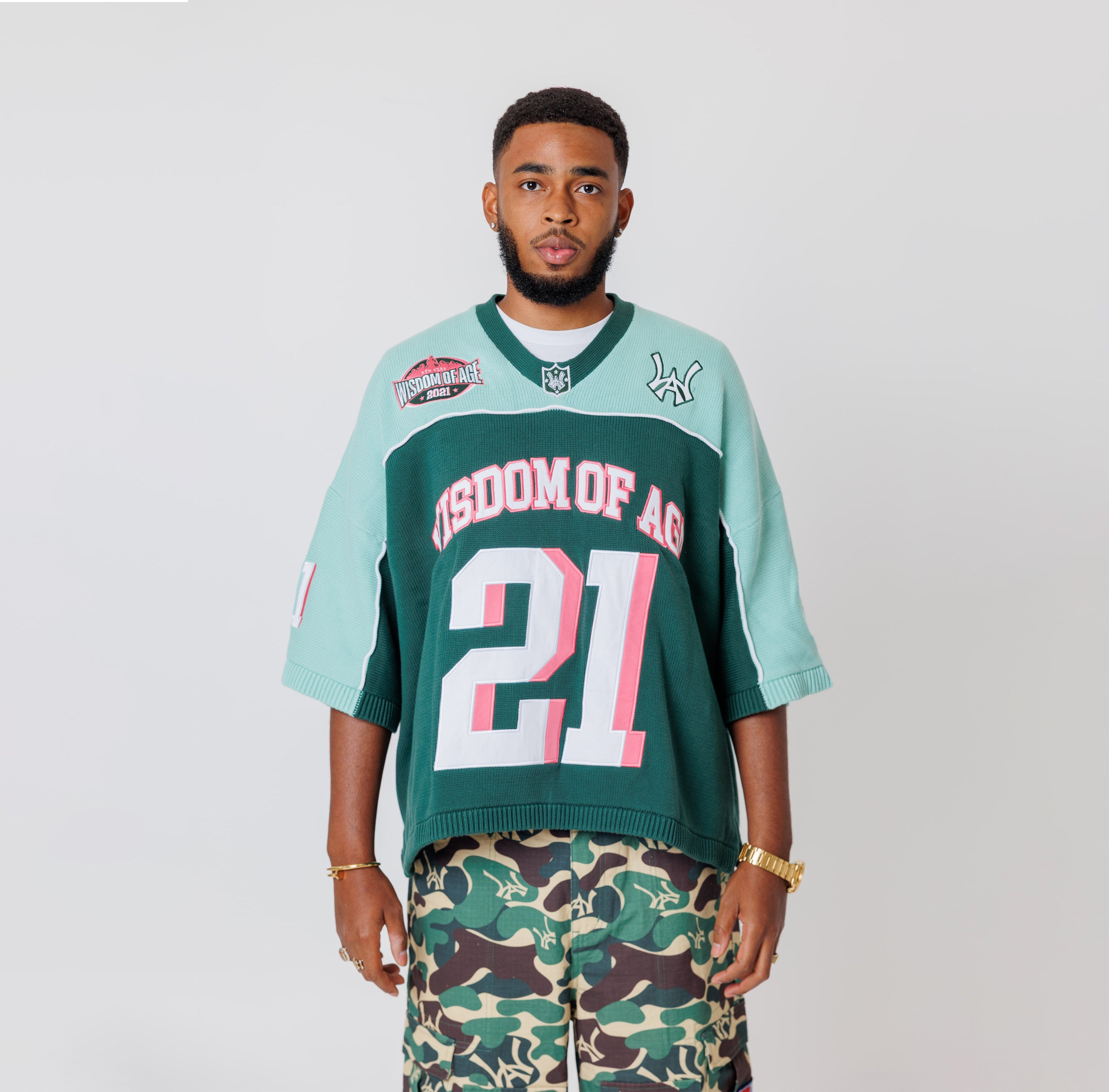 Male Model wearing a the WOA Football jersey V2 in the Mint color with 'Wisdom Of Age' and number '21' embroidered on the front. Model is wearing the WOA Camo Cargos on a white background.