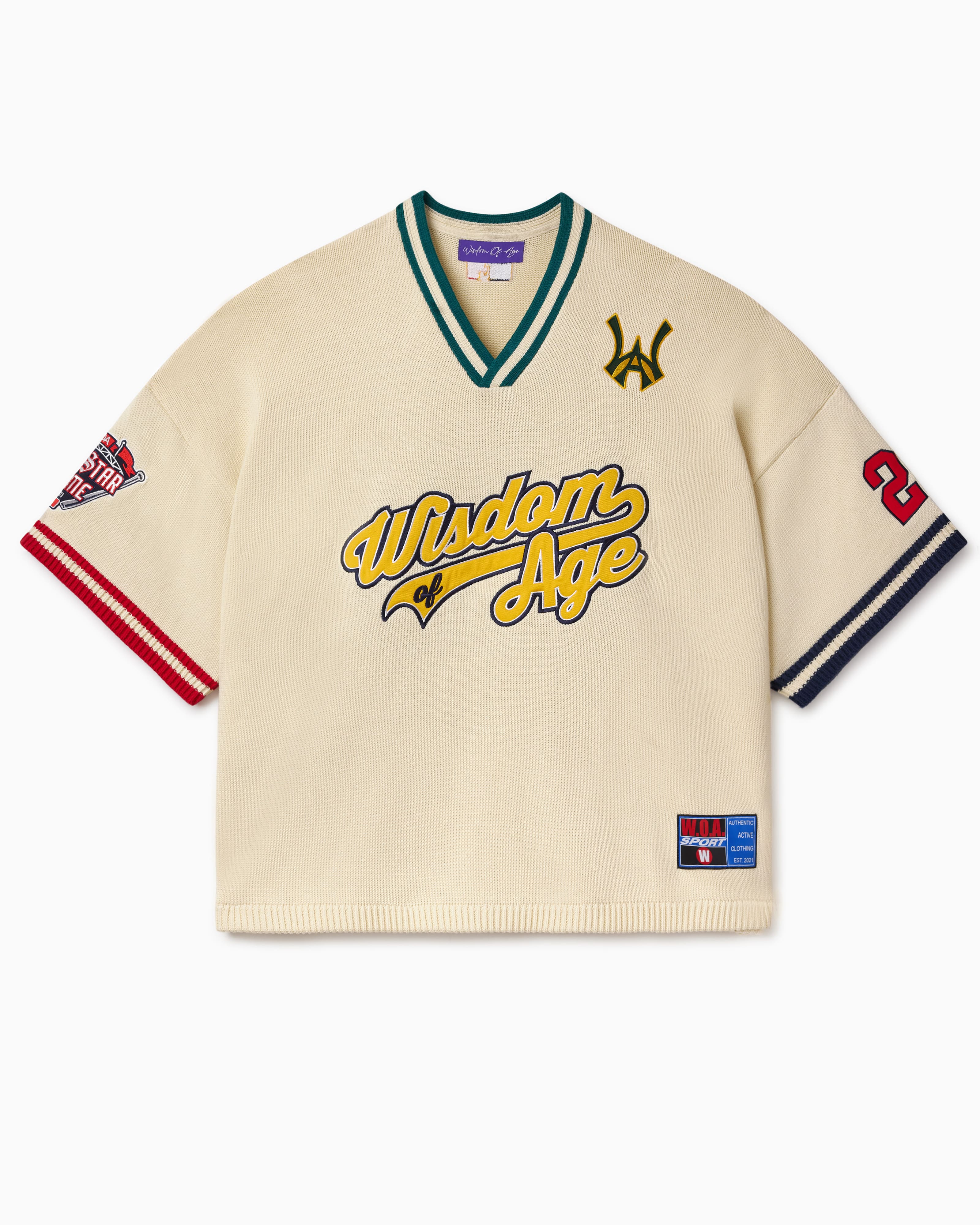 Knitted Baseball Jersey in Cream with 'Wisdom of Age' written in text and various logos on a white background