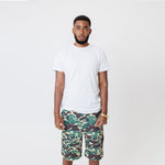 Male Model wearing a white t-shirt and the WOA convertible Cargo shorts in Camo color on a white background.
