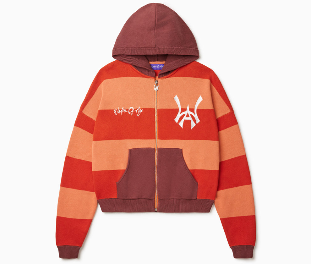 Front View Of the Wisdom Of Age Knit Zippered Hoodie. There are alternating horizontal orange stripes. One stripe is a darker shade of Orange. WA logo on left chest, Wisdom Of Age written in the signature font on the right chest. Kangaroo pockets separated by the zipper.