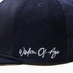 Wisdom Of age Logo Fitted Hat Navy side view Close up