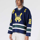 Front Side View Of A Male Model wearing The Navy, Yellow and Green Wisdom Of Age Knit Hockey Jersey.