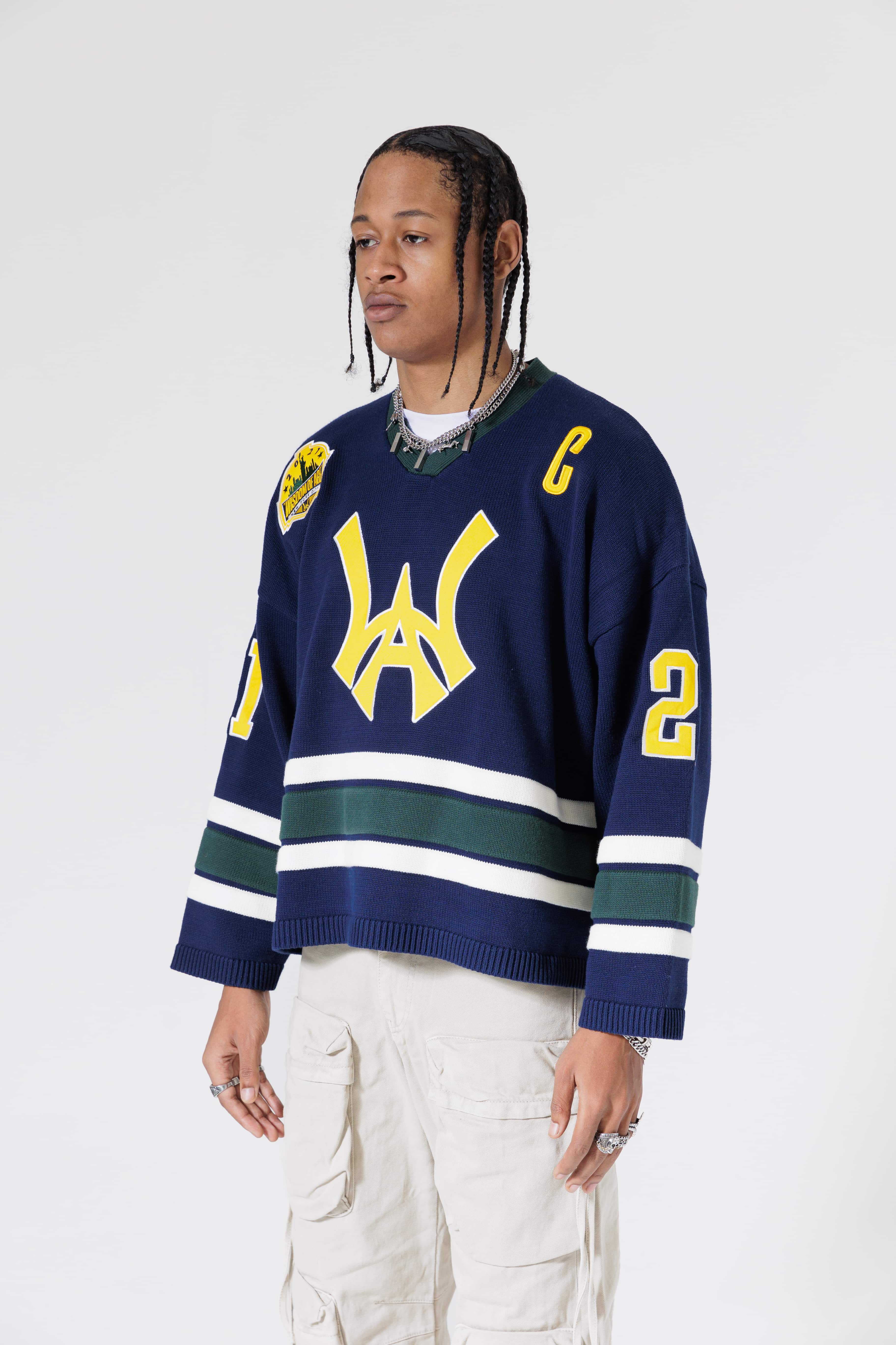 Front Side View Of A Male Model wearing The Navy, Yellow and Green Wisdom Of Age Knit Hockey Jersey.