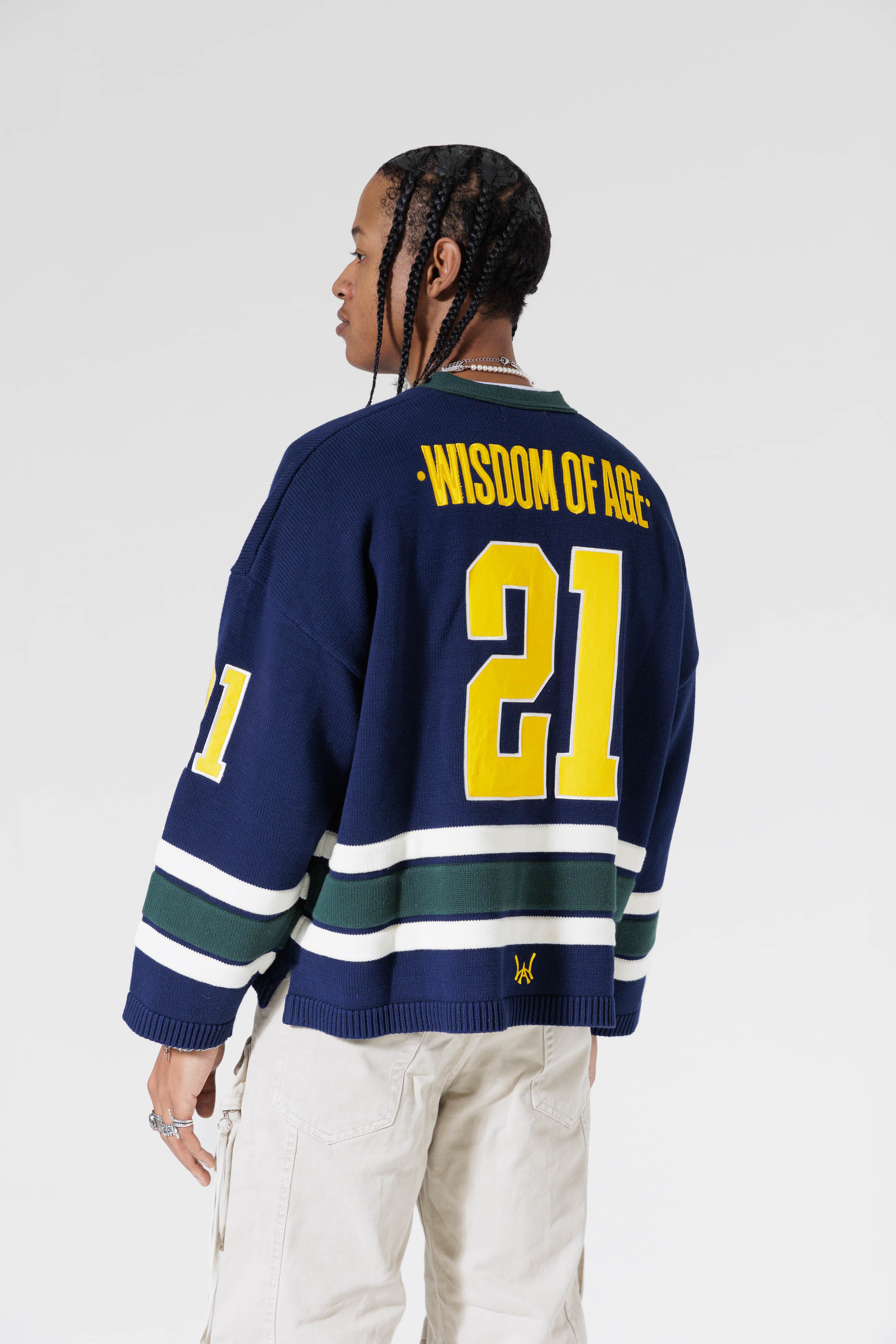 Reat View Of A Male Model wearing The Navy, Yellow and Green Wisdom Of Age Knit Hockey Jersey.