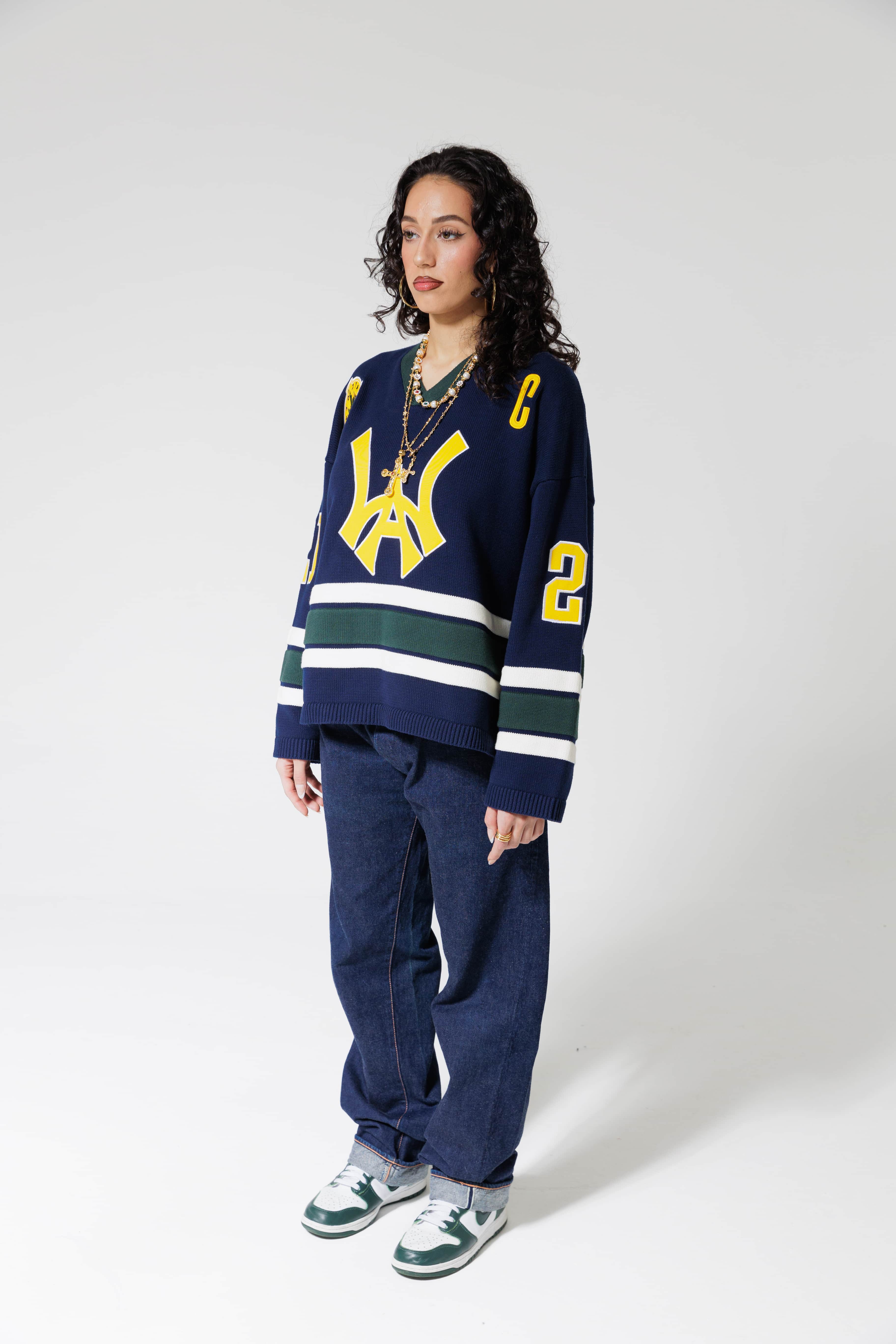 Full body Front View Of A Female Model wearing The Navy, Yellow and Green Wisdom Of Age Knit Hockey Jersey.