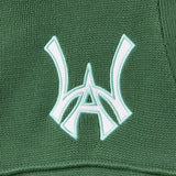 Close-up of a sage green fabric with a white WA logo on a textured background