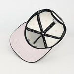 Under visor of the White and Black WOA baseball cap on a white background