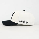 White and black cap with 'Wisdom of the Ages' text on a white background