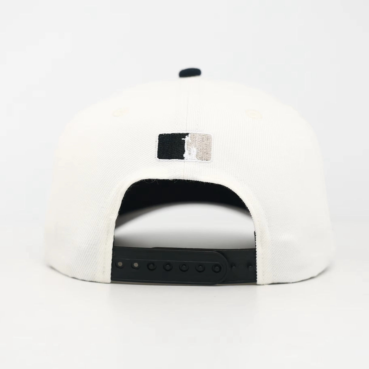 White and Black snapback cap with the WOA Liberty logo on the back against a white background