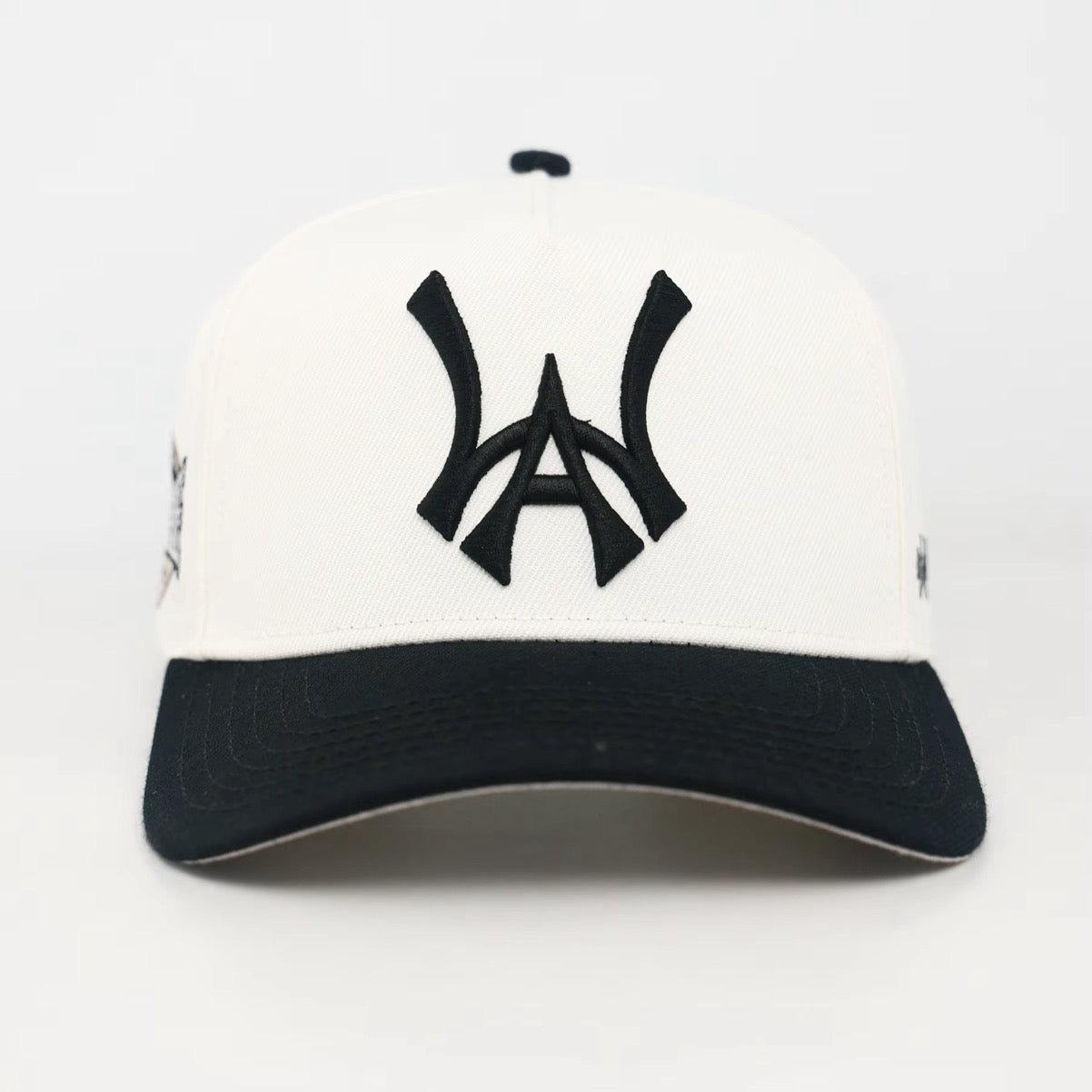 White and Black baseball cap with a Black WA logo on a white background