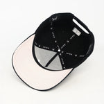 Under Visor of the WA Black cap with text on a white background