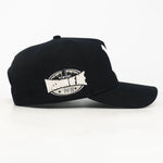 side view of a Black baseball cap with a white Wisdom of age logo on a white background