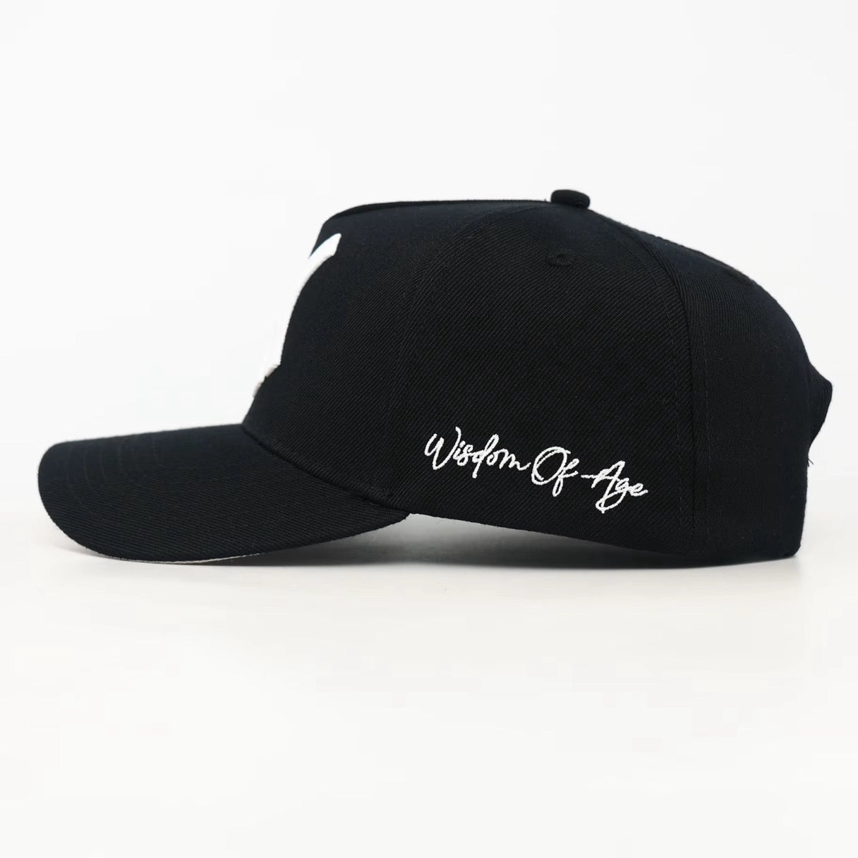 Black cap with 'Wisdom Of Age' text on a white background