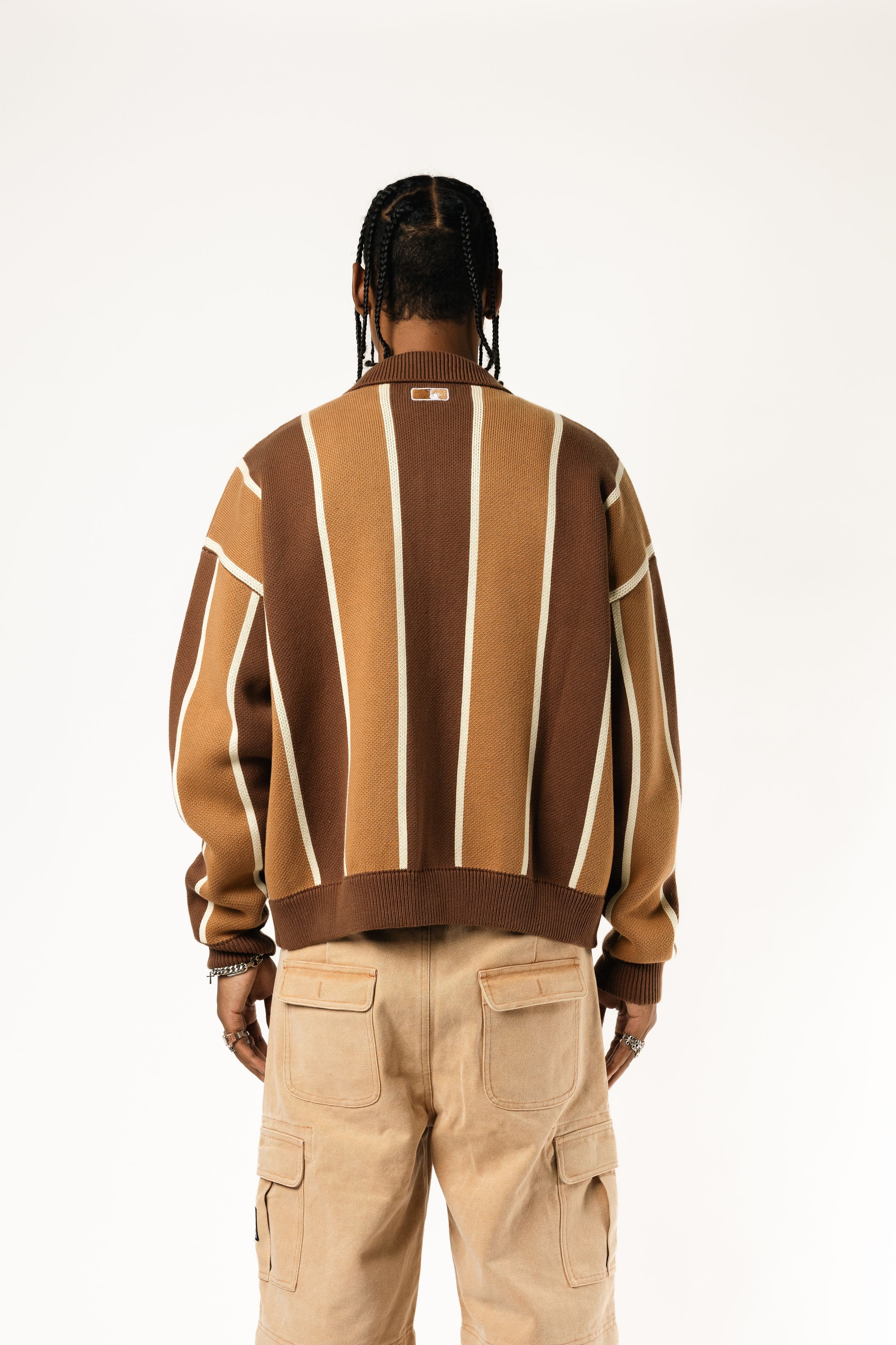 Rear view of a Male model wearing the WOA Knitted Brown and beige striped cardigan  on a white background.