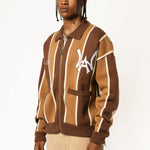 Male model wearing the WOA Knitted Brown and beige striped cardigan with WA logo on the left chest and 'Wisdom Of Age' written in script on the right chest on a white background.