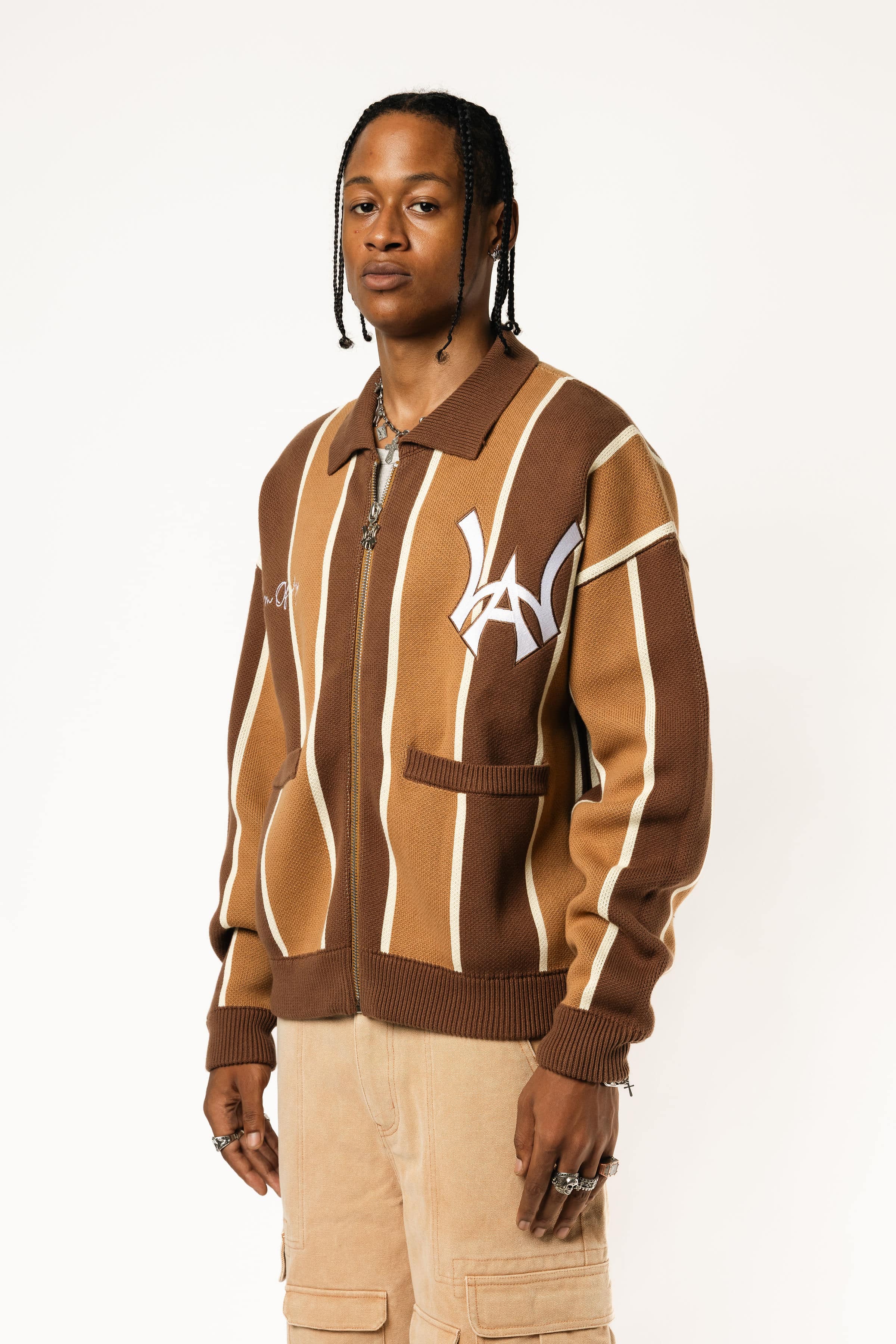 Male model wearing the WOA Knitted Brown and beige striped cardigan with WA logo on the left chest and 'Wisdom Of Age' written in script on the right chest on a white background.