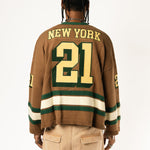 Rear view of a male Model wearing the WOA Knitted Hockey Jersey with Embroidered 'NEW YORK' and the number 21 standing against a white background.
