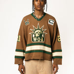 Male Model wearing the WOA Knitted Hockey Jersey with Embroidered WA logo, Captains patch and W.O.A liberty graphic standing against a white background.
