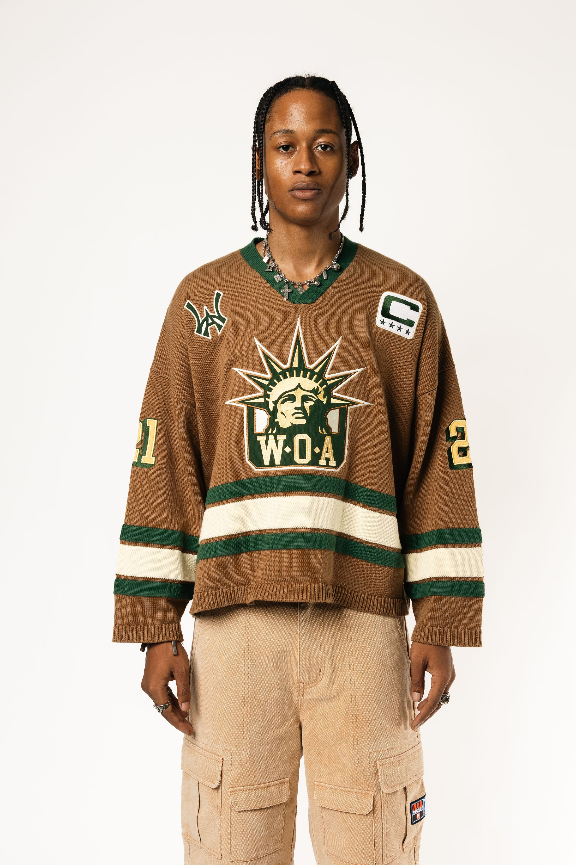 Male Model wearing the WOA Knitted Hockey Jersey with Embroidered WA logo, Captains patch and W.O.A liberty graphic standing against a white background.