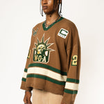 Front-side view of a Male Model wearing the WOA Knitted Hockey Jersey with Embroidered WA logo, Captains patch and W.O.A liberty graphic standing against a white background.